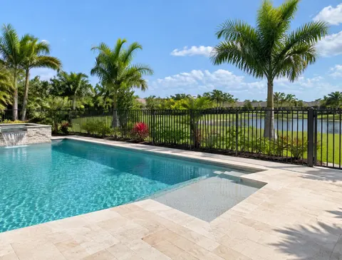 Residential pool enclosed by a black aluminum fence with a matching gate